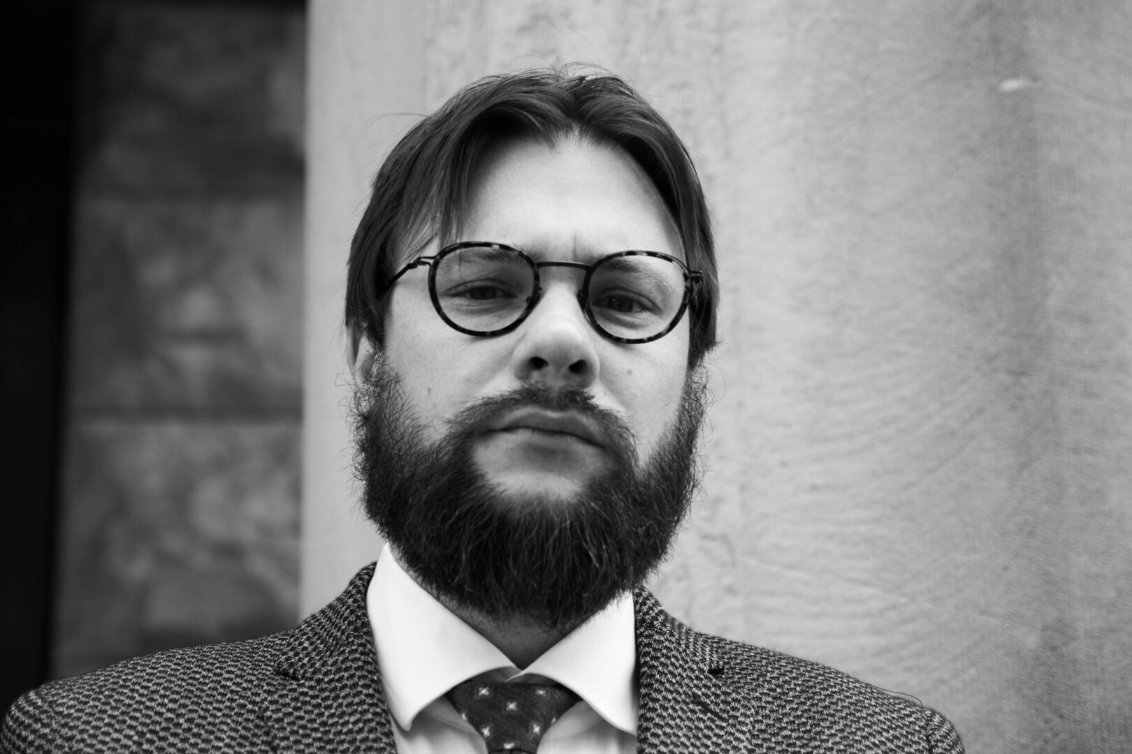 A man with long hair and beard wearing glasses.